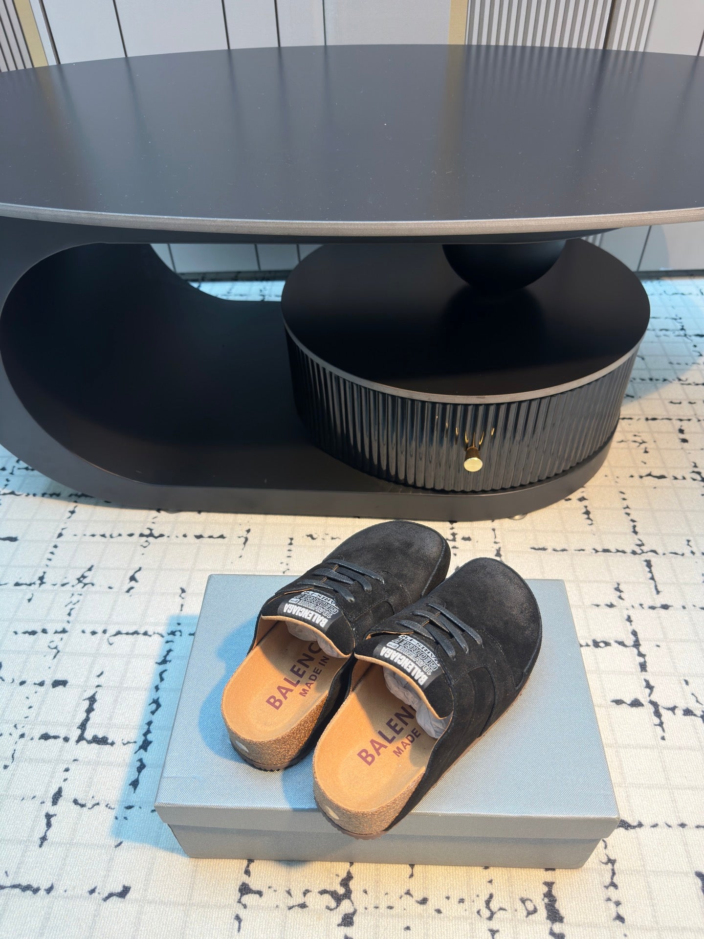 Balenciaga black lace-up slip-on shoes, stacked pair showing insoles and heel area.