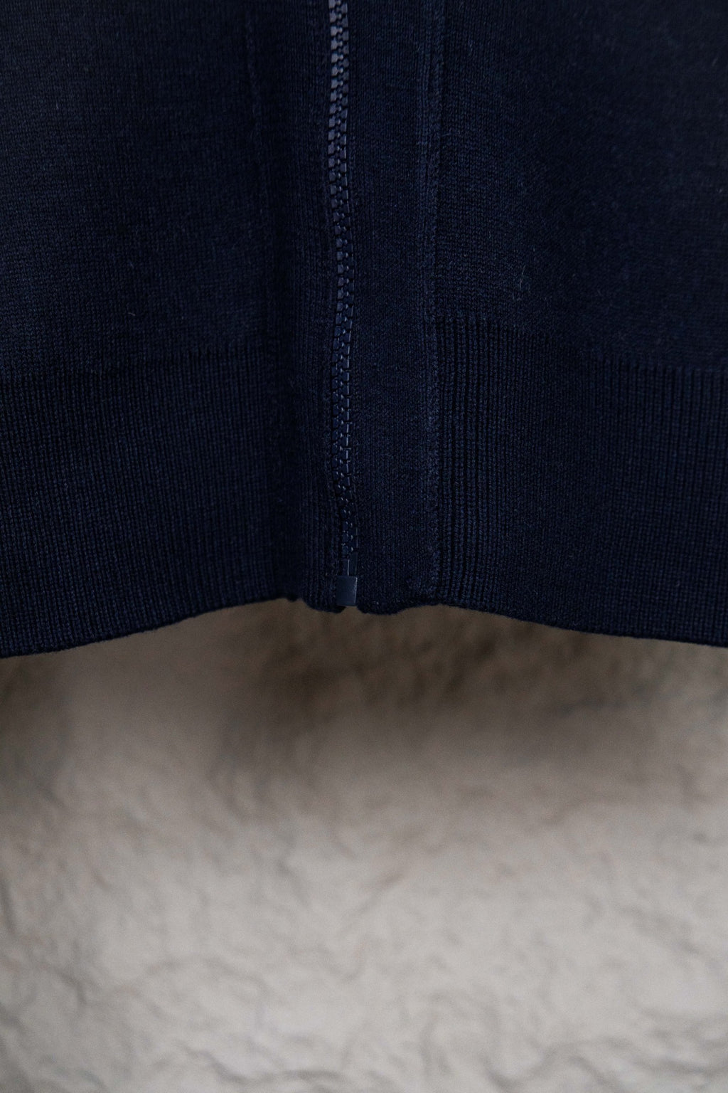 Navy knit cardigan with center zipper and ribbed bottom hem