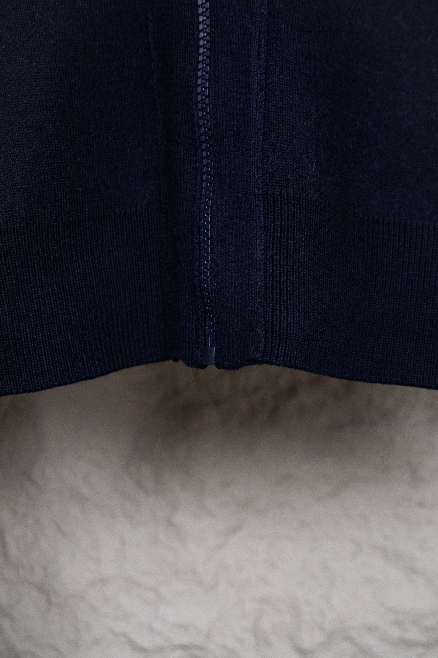 Navy knit cardigan with center zipper and ribbed bottom hem