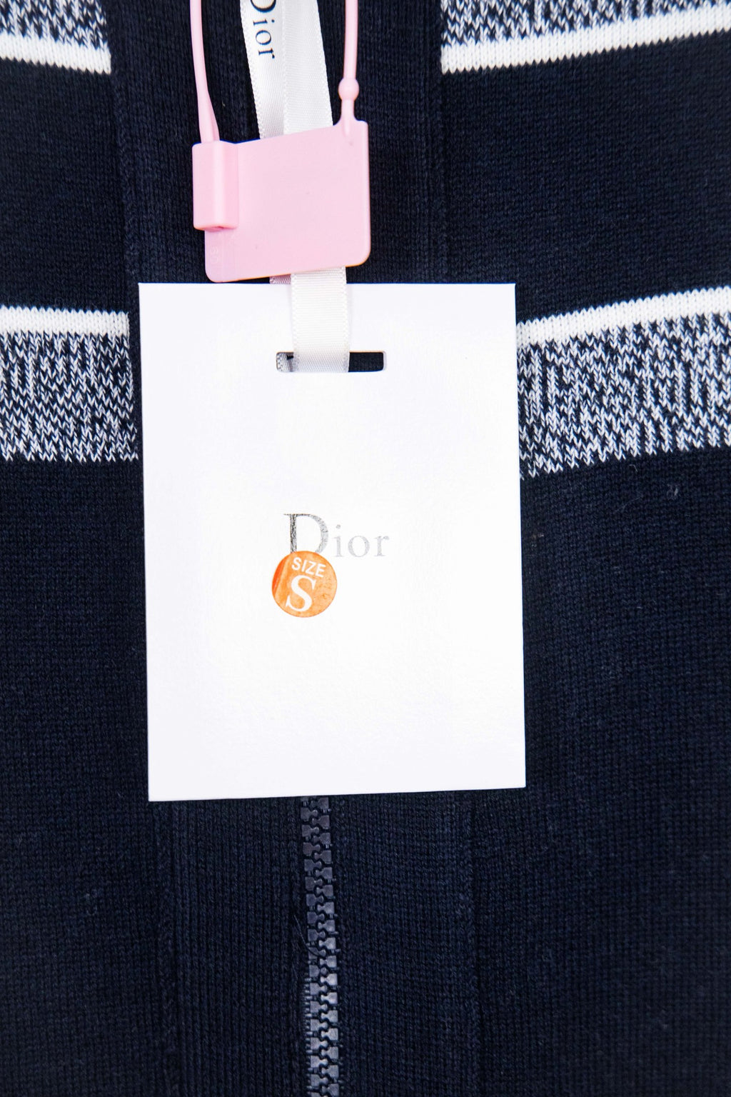 Dior clothing tag and price card attached to navy knit zip cardigan