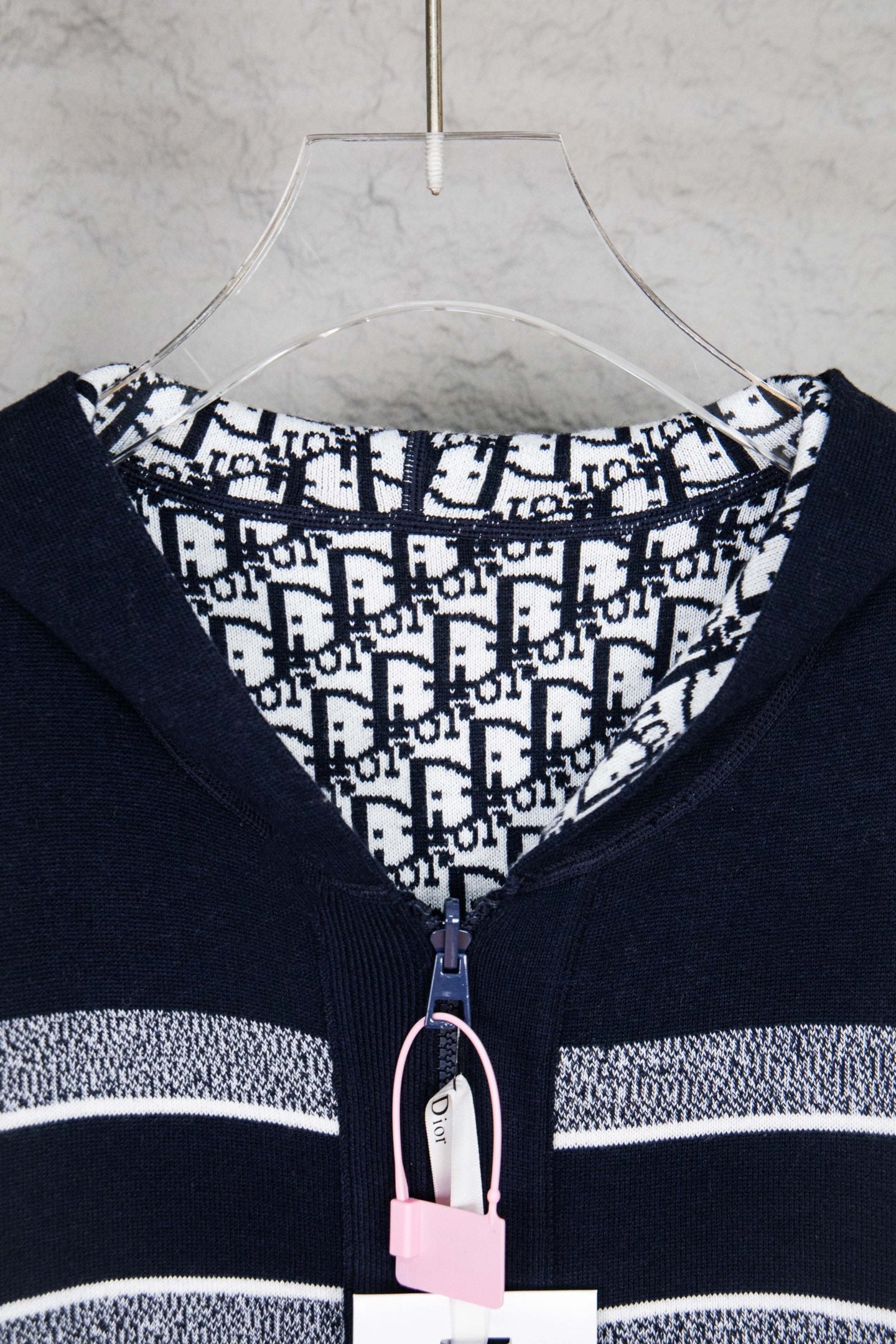Navy zip-up cardigan with patterned inner hood and front zipper pull