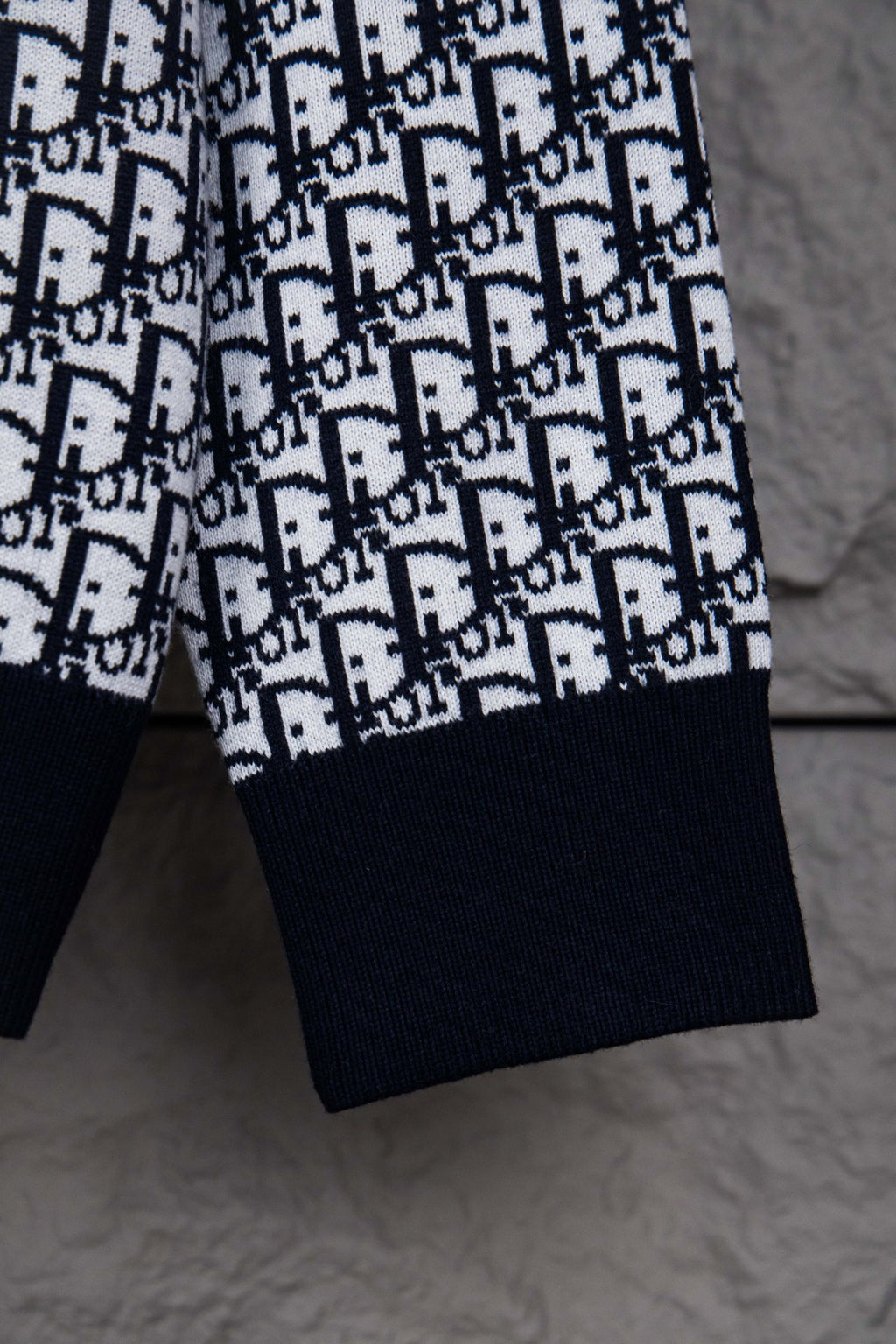 Dior knit jacket sleeve with navy cuff and repeating monogram pattern