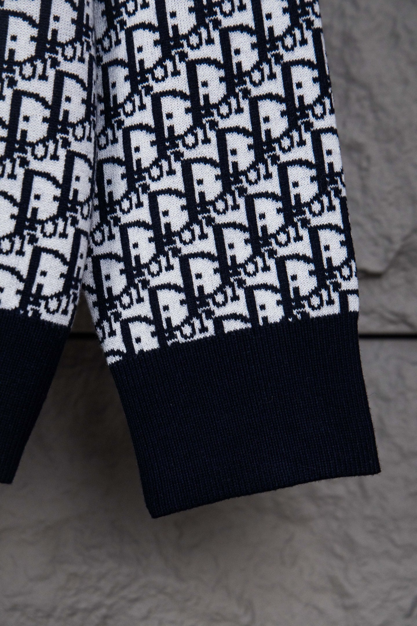 Dior knit jacket sleeve with navy cuff and repeating monogram pattern
