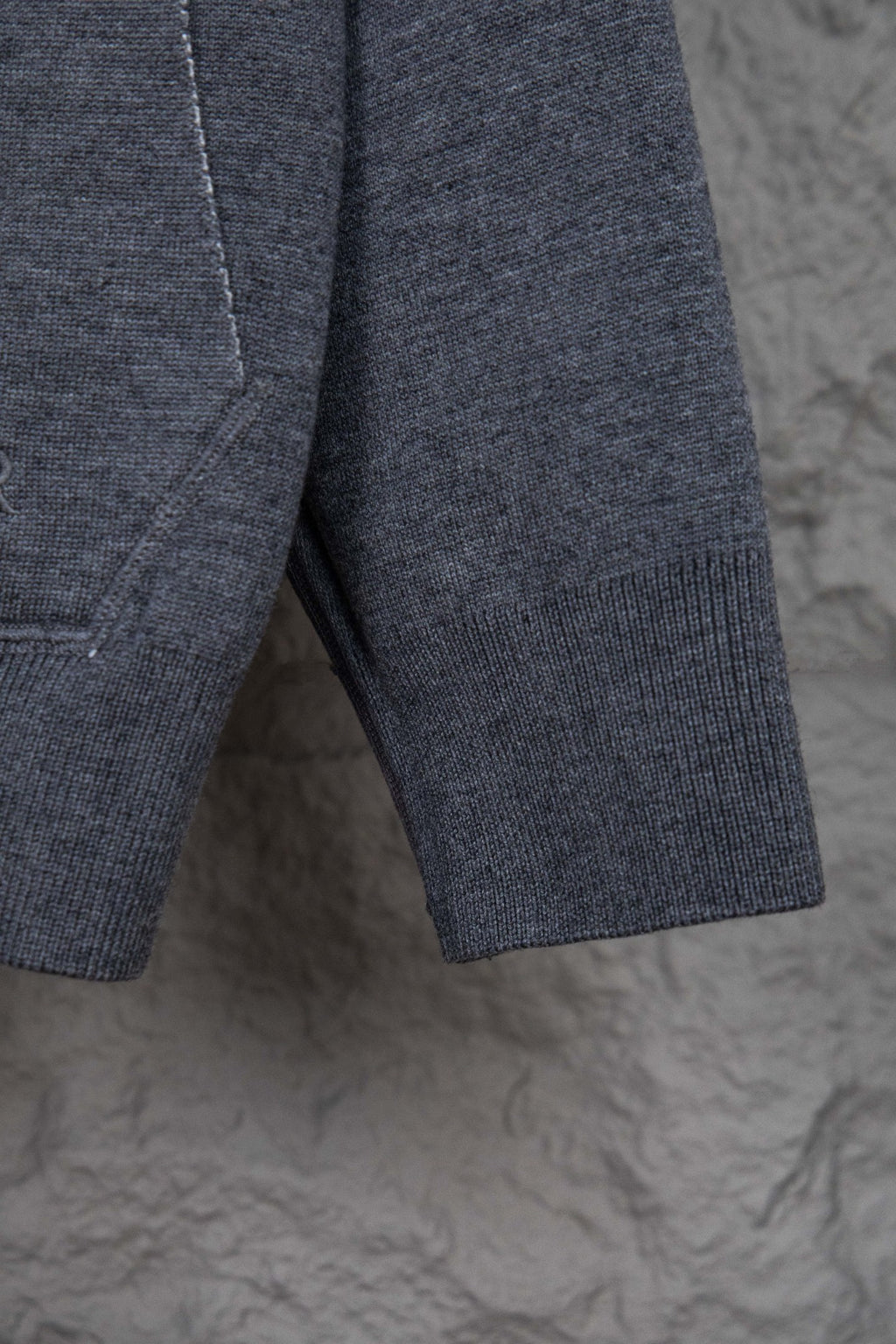 Heather gray hoodie hem with ribbed cuffs and side seam stitching
