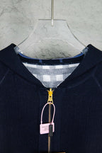 Close-up of navy hooded zip-up knit jacket, front zipper and check-lined hood