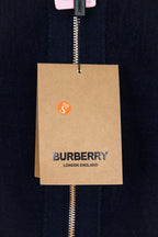 Navy zip-up knit jacket fabric with hanging Burberry logo tag on zipper
