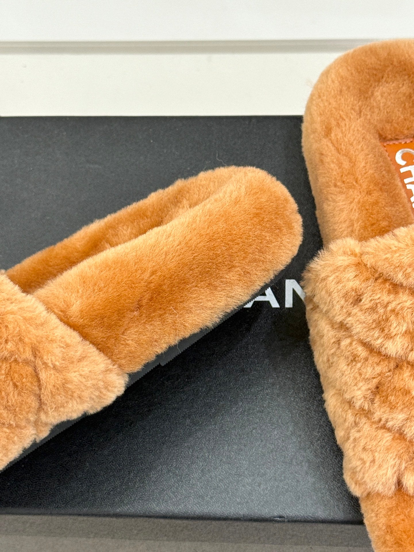 Close-up of tan fuzzy Chanel slide slipper footbed and soft upper