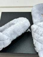 Light blue plush slide sandals showing curved toe strap and soft textured surface