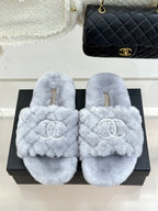 Light blue plush slide sandals with round toe and logo emblem on front