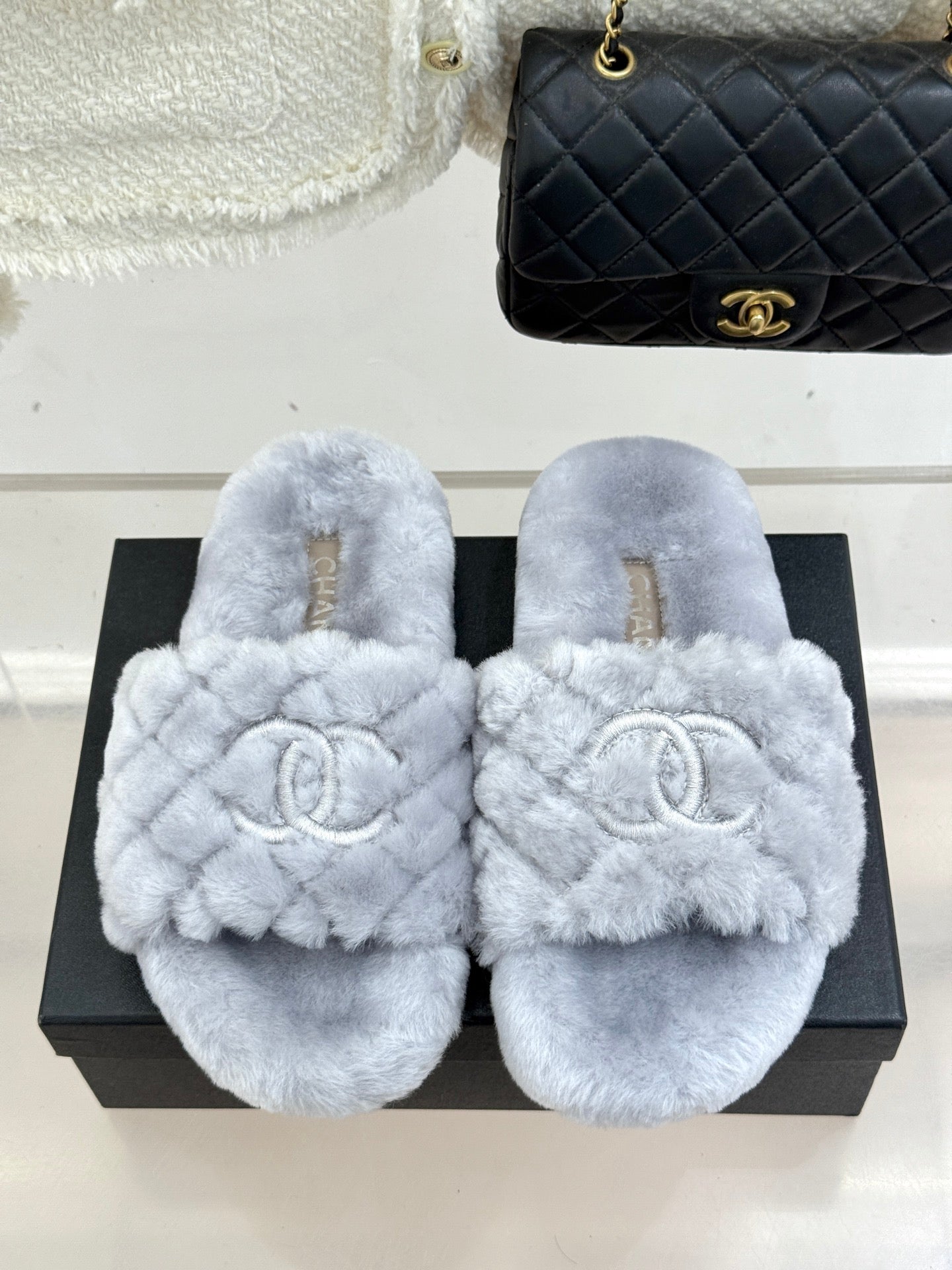 Light blue plush slide sandals with round toe and logo emblem on front