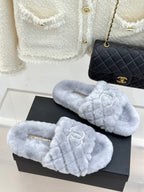 Light blue plush slip-on sandals with double logo emblem on crisscross strap