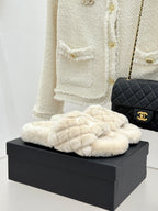 Cream plush slide sandals with quilted bow detail and interlocking logo on front