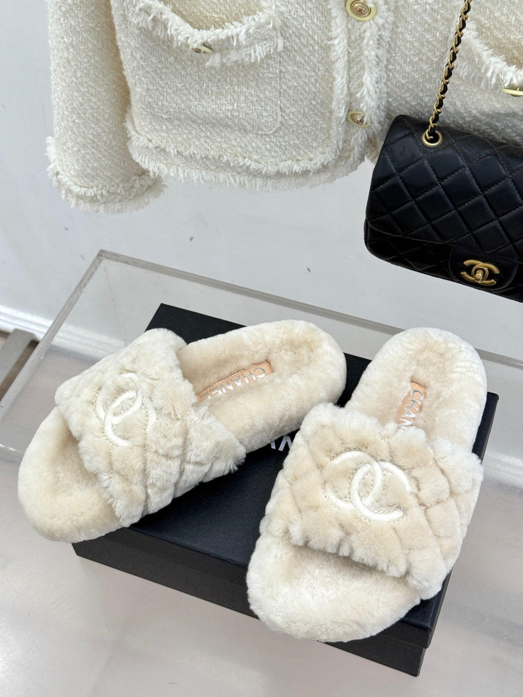 Cream plush bow-front slide sandals with double-C logo, shown on black box