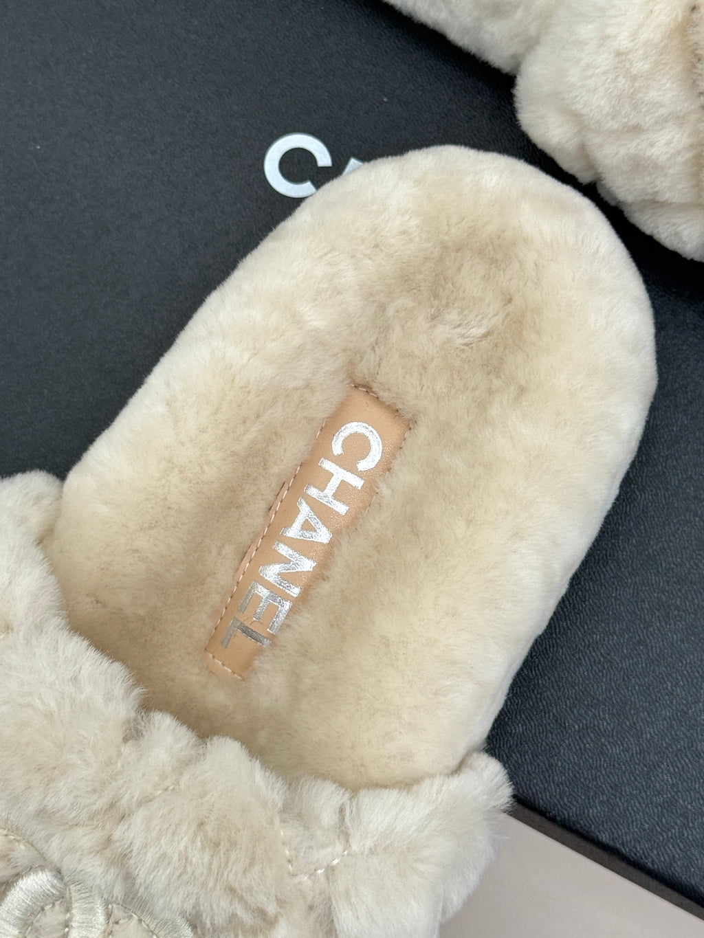 Cream plush slide sandal with CHANEL monogram patch on insole