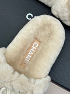 Cream plush slide sandal with CHANEL monogram patch on insole