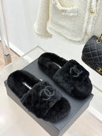 Dark faux-fur Chanel slides, front view on gray display box
