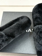Close-up of dark faux-fur Chanel slide strap on gray box