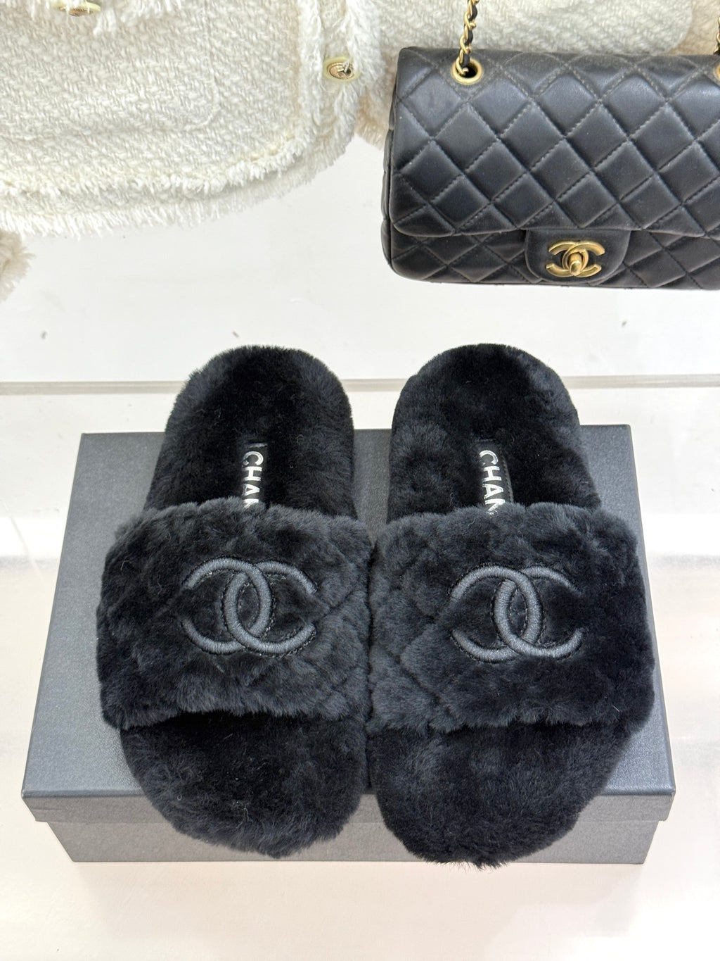 Dark faux-fur Chanel slides with large CC logos on the front strap