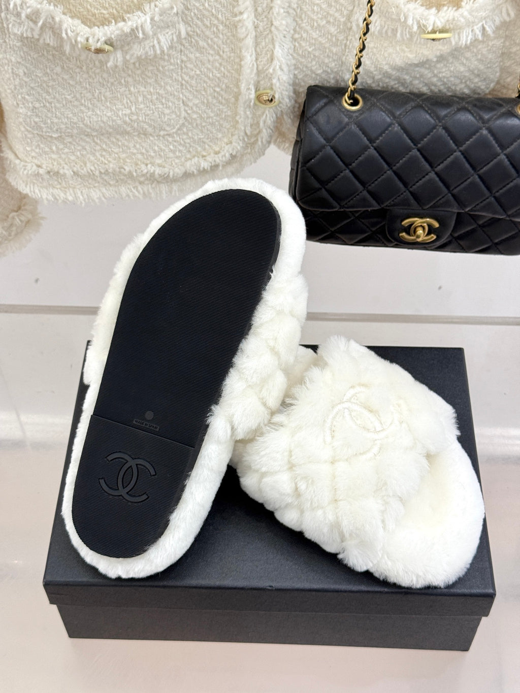 White faux-fur slip-on mules with Chanel logo, on black display box