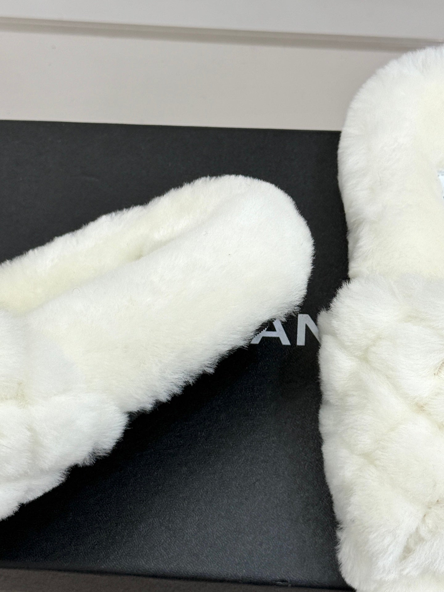 White faux-fur mule with Chanel logo detail on black box