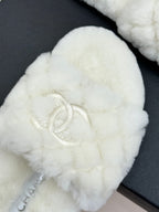 Close-up: white faux-fur round-toe mule with Chanel logo stitch