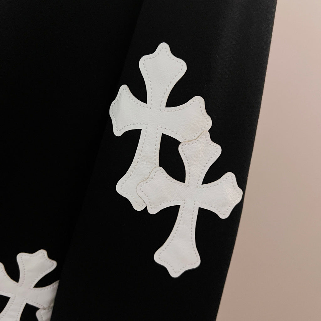 Black sweatshirt sleeve with three white cross appliques