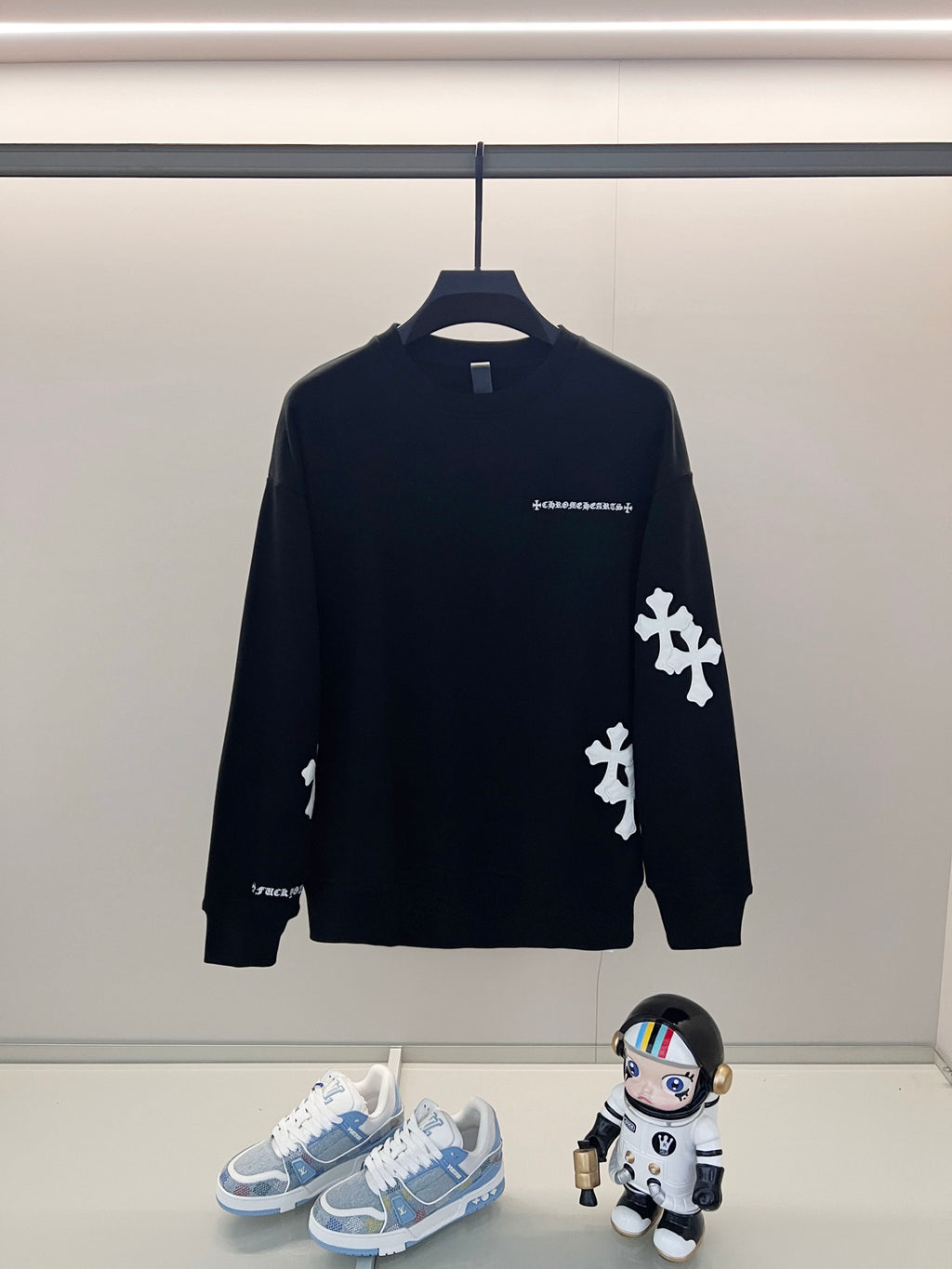 Black crewneck sweatshirt with white cross applique and small chest logo