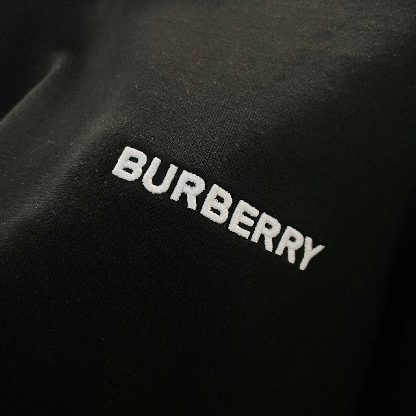 Navy sweatshirt fabric with embroidered BURBERRY lettering across the chest