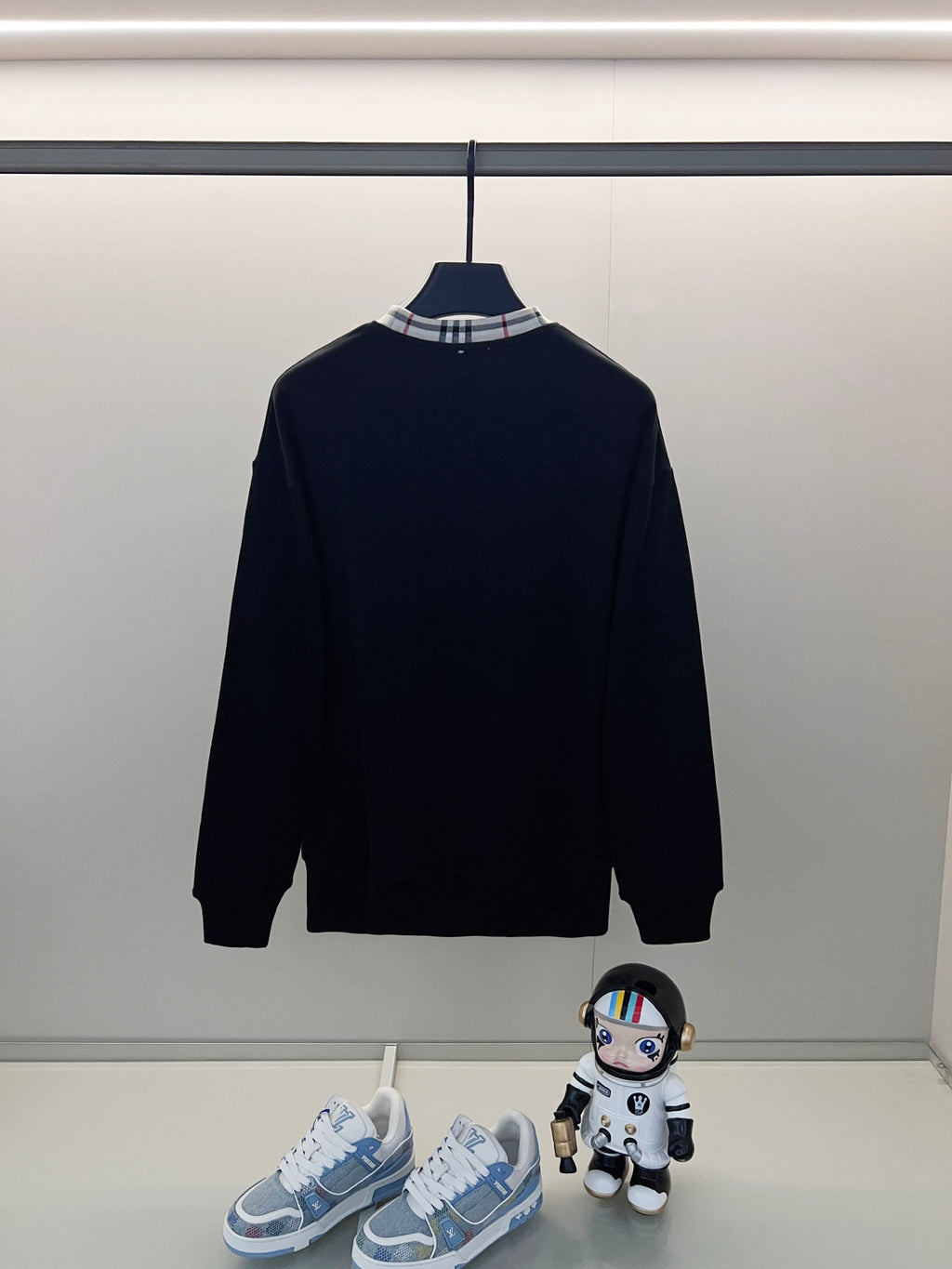 Navy crewneck sweatshirt on hanger with ribbed cuffs and hem; Burberry logo on chest