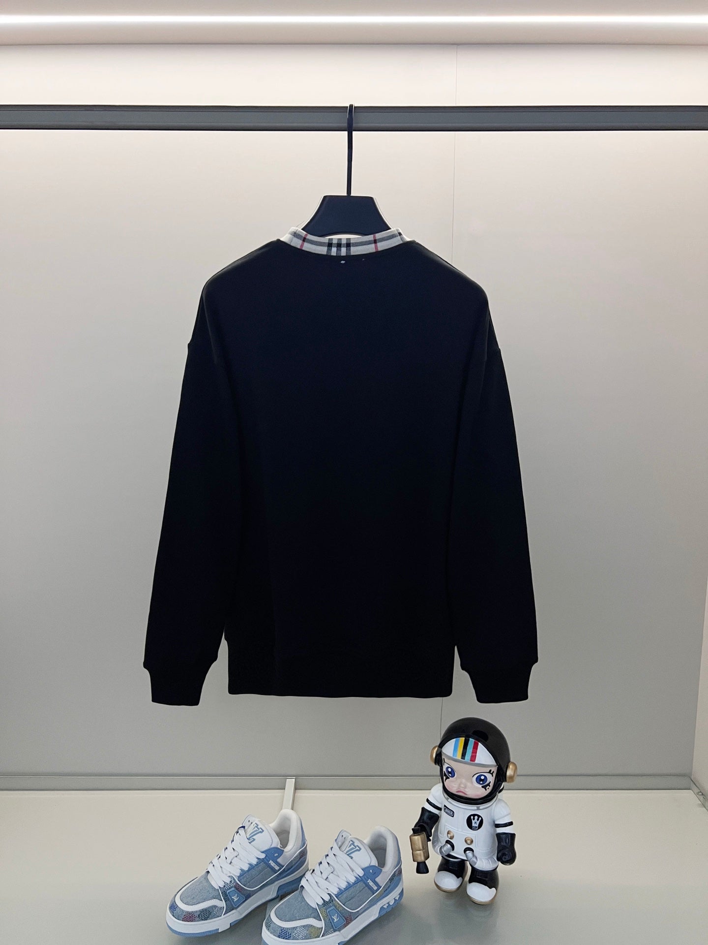 Navy crewneck sweatshirt on hanger with ribbed cuffs and hem; Burberry logo on chest