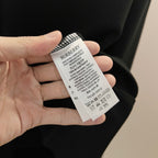 Navy sweatshirt fabric tag held in hand with Burberry product information