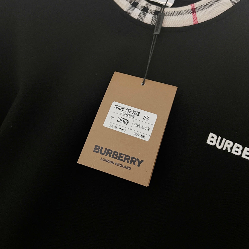 Navy sweatshirt with hanging fabric tag and Burberry label detail near the collar