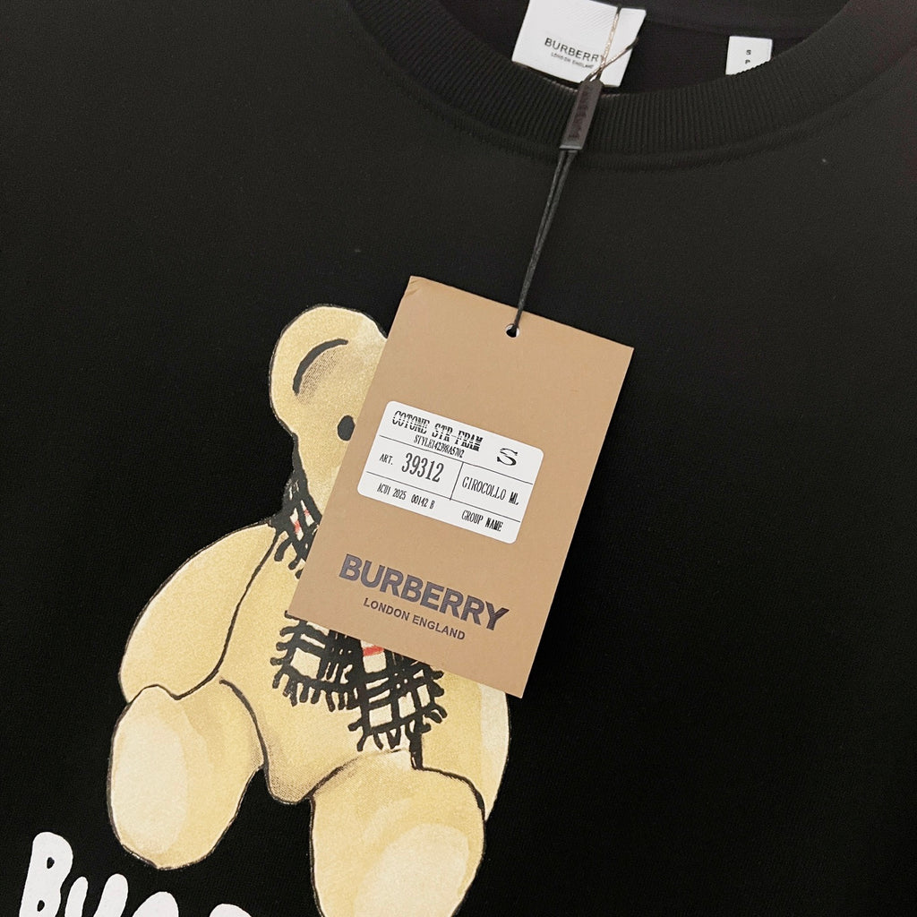 Kids long-sleeve sweatshirt, dark navy, care label tag attached near bear print