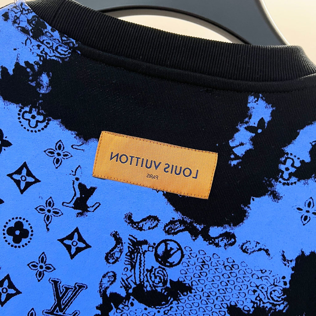 Sweatshirt front close-up with blue-and-black all-over pattern and tan brand patch