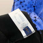Size label and black knit hem on blue-and-black patterned sweatshirt