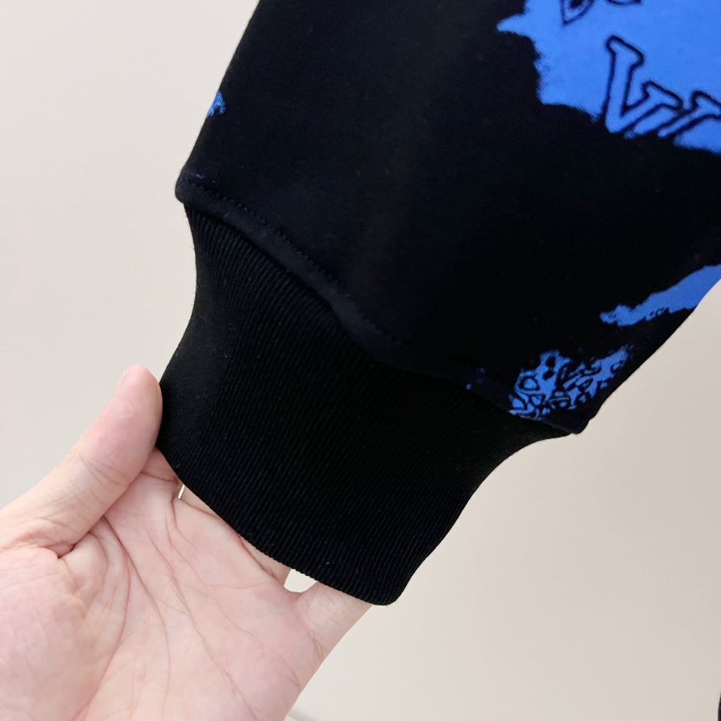 Ribbed cuff and hem detail on blue-and-black sweatshirt sleeve