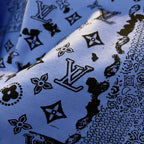 Sweatshirt fabric close-up showing blue ground with black icon and monogram motifs