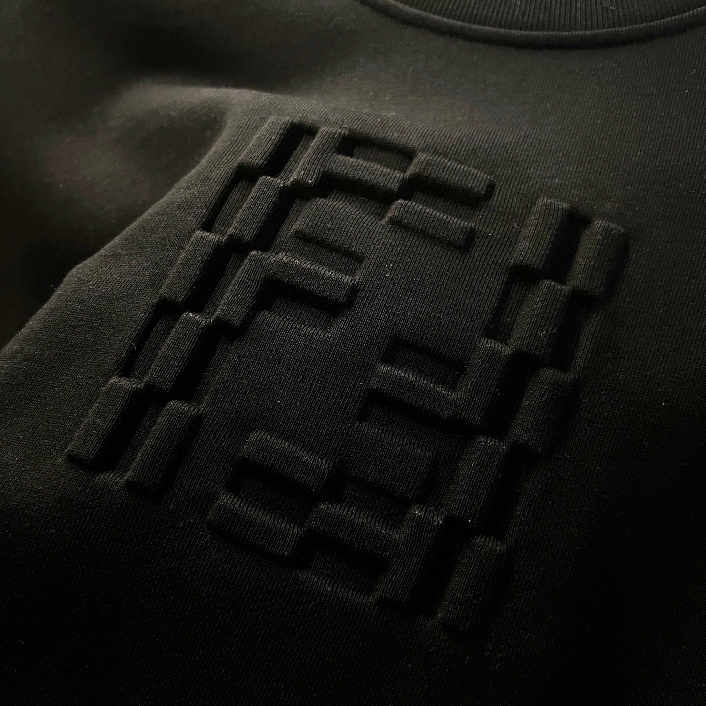 Black sweatshirt fabric with raised Fendi logo embroidery detail