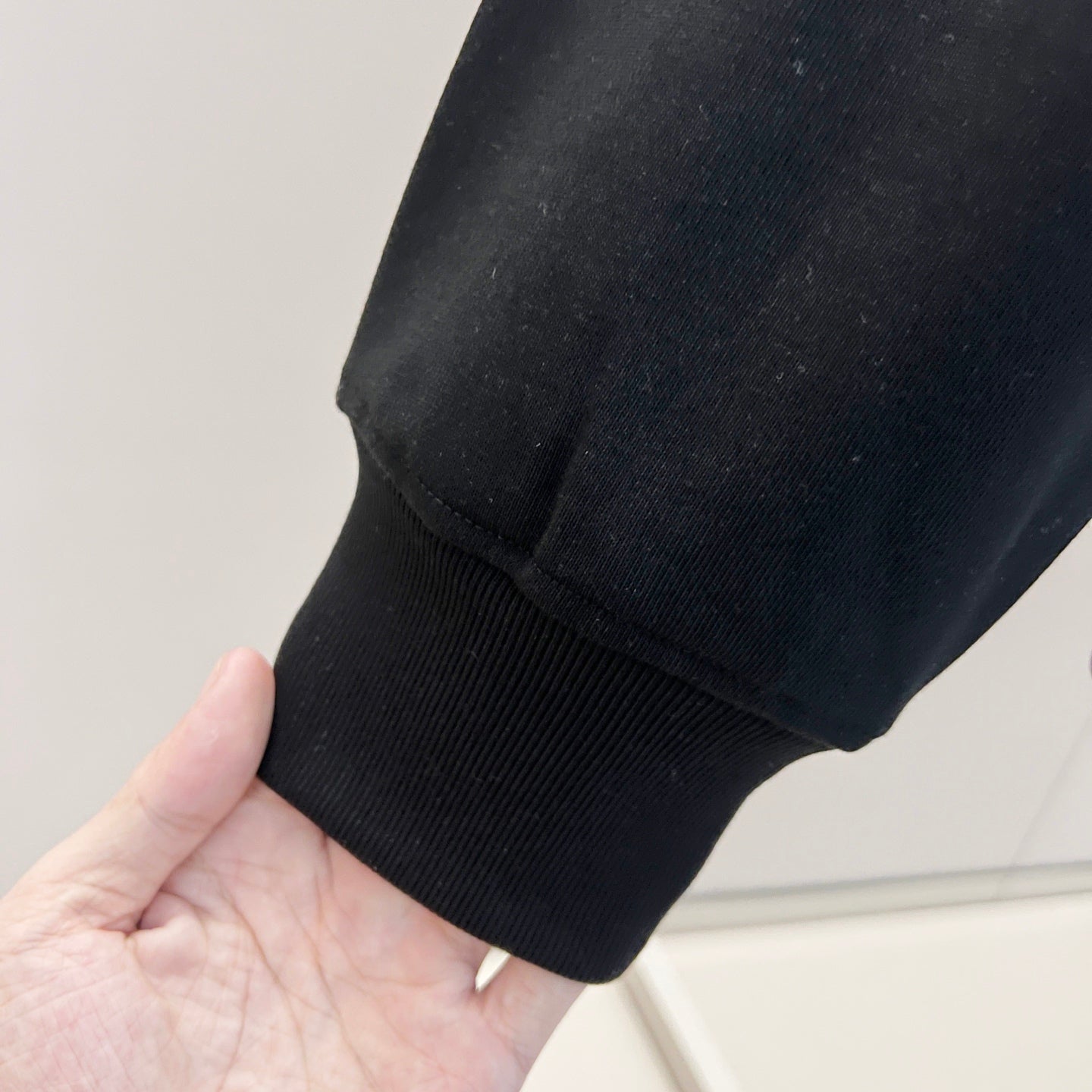 Black sweatshirt sleeve cuff with ribbed knit trim