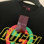 Black sweatshirt with large multicolor GUCCI graphic logo, hanging brand tag.