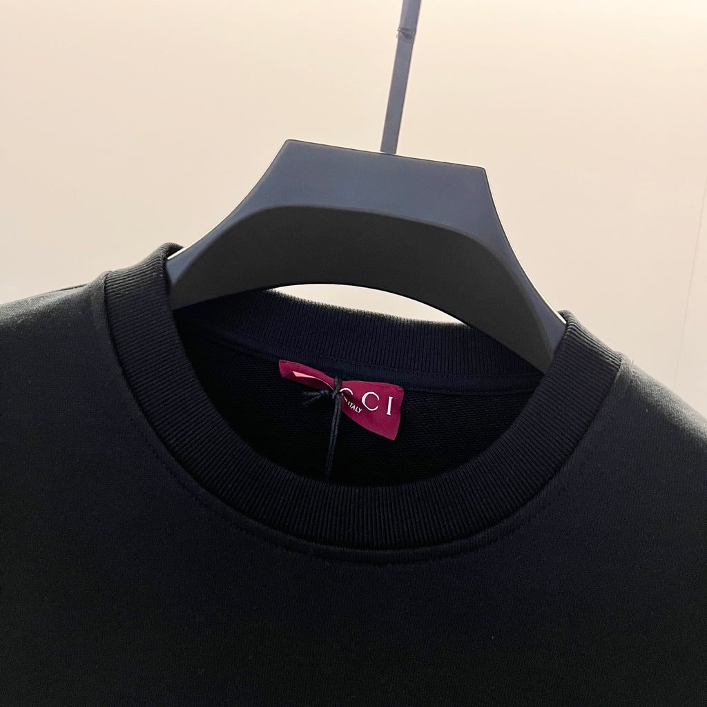 Black crewneck sweatshirt neckline with ribbed collar and inner label.