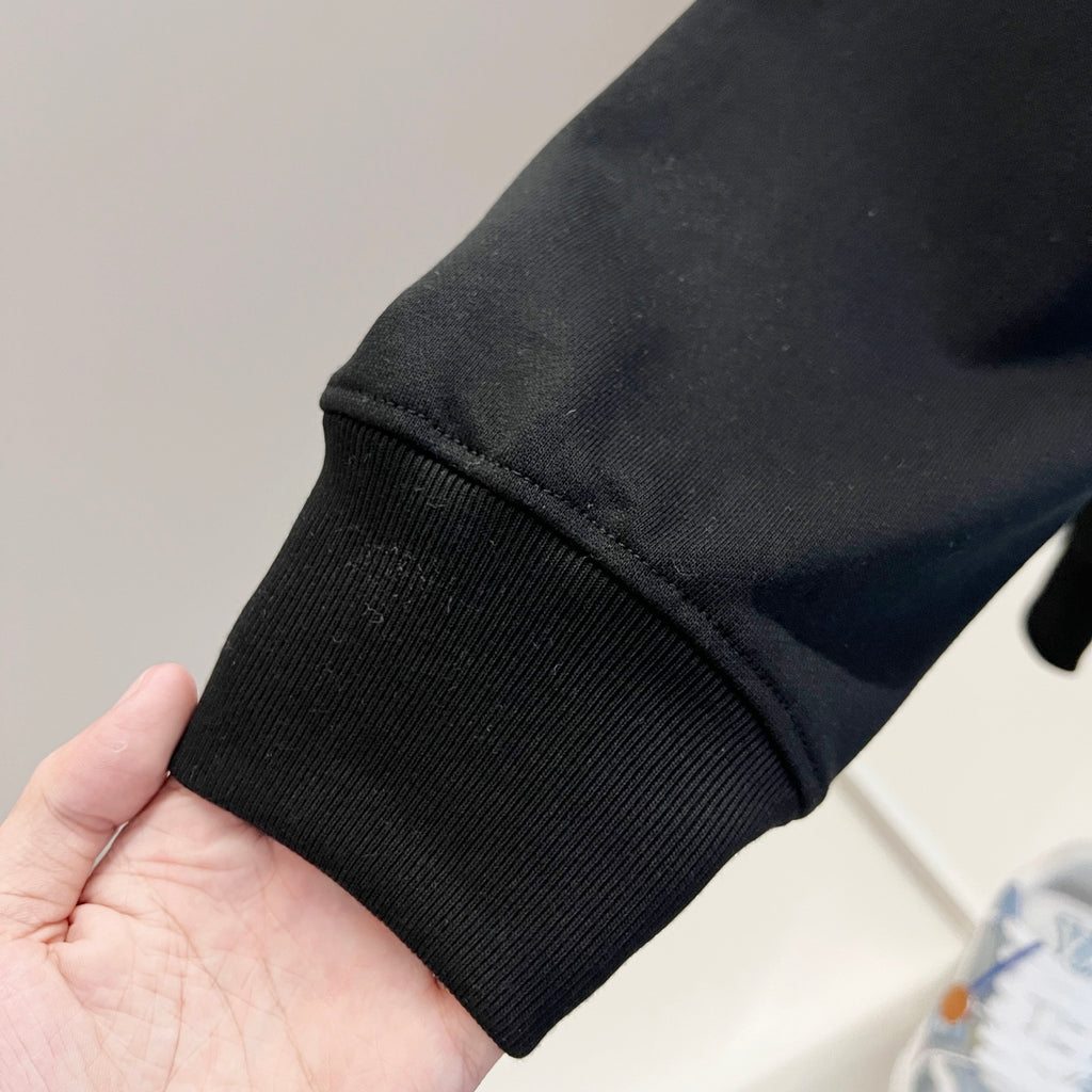 Black sweatshirt sleeve cuff with ribbed knit hem detail.