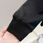 Black sweatshirt sleeve cuff with ribbed knit hem detail.