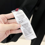 Black sweatshirt showing care label tag attached near the neck opening.