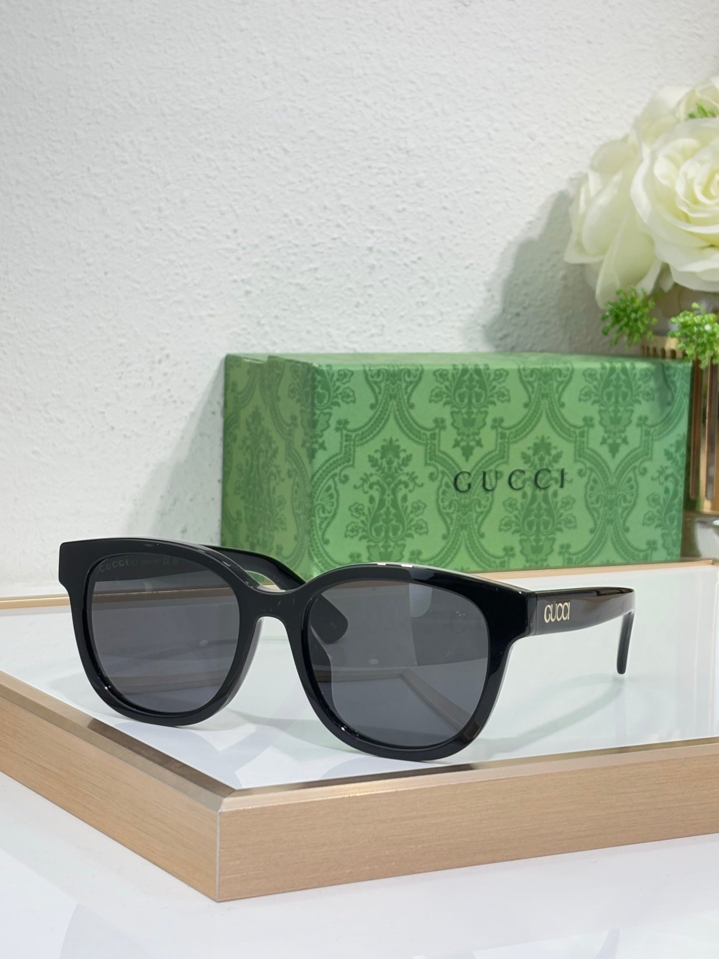 Gucci sunglasses with black oversized frames and dark tinted lenses