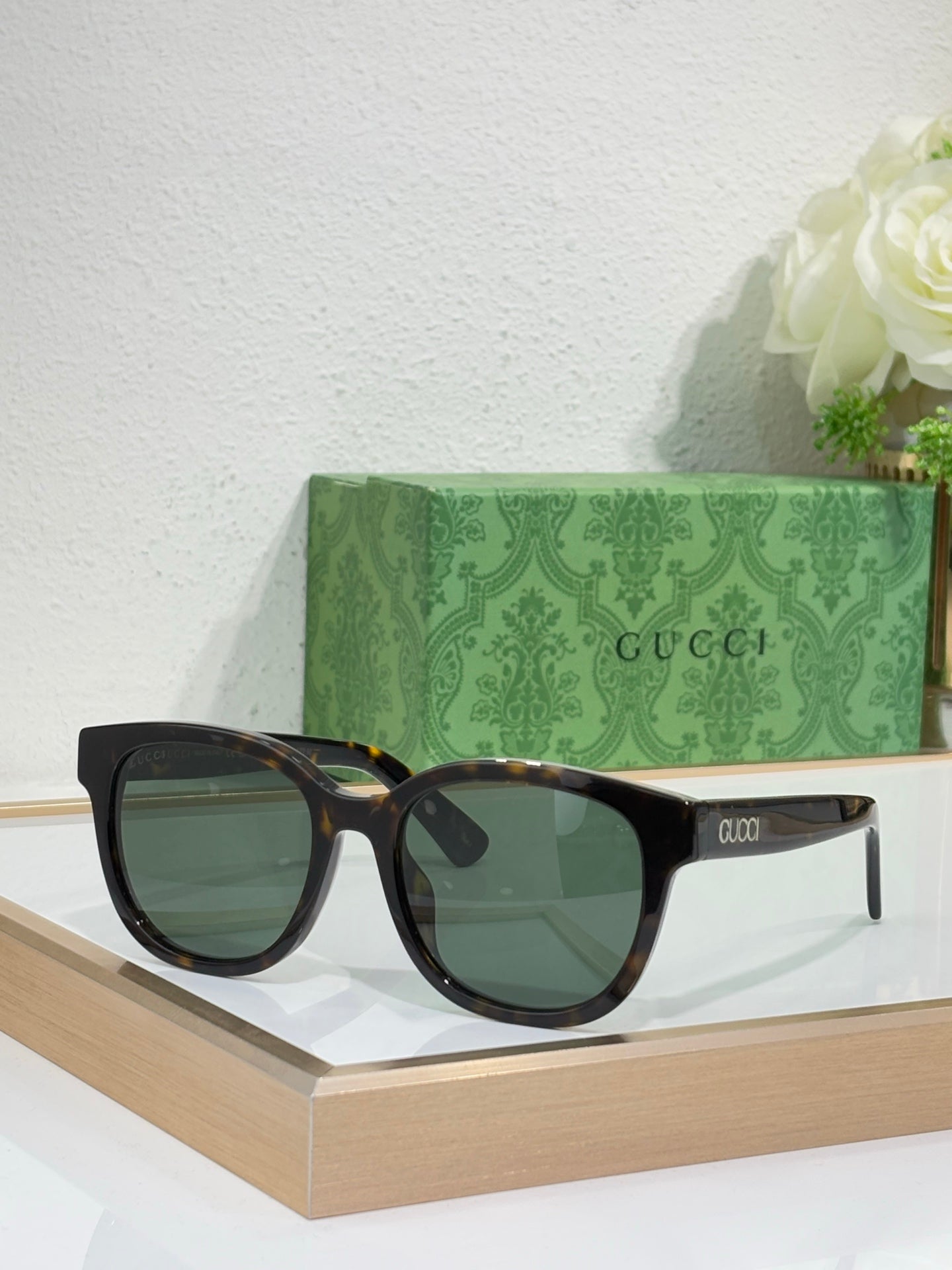 Gucci cat-eye sunglasses with tortoiseshell arms and dark tinted lenses