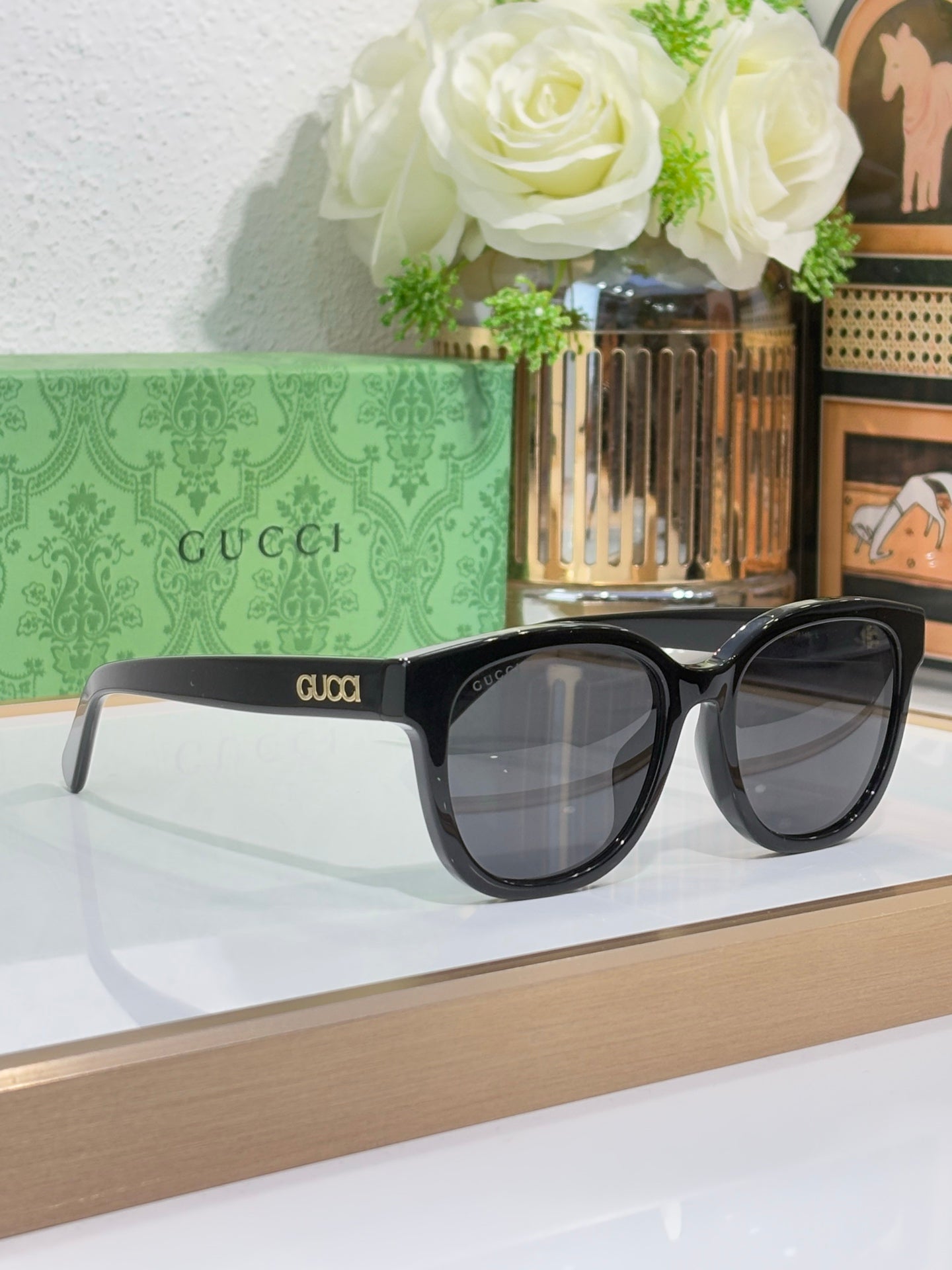 Gucci sunglasses with dark frames and large square lenses, logo on temples