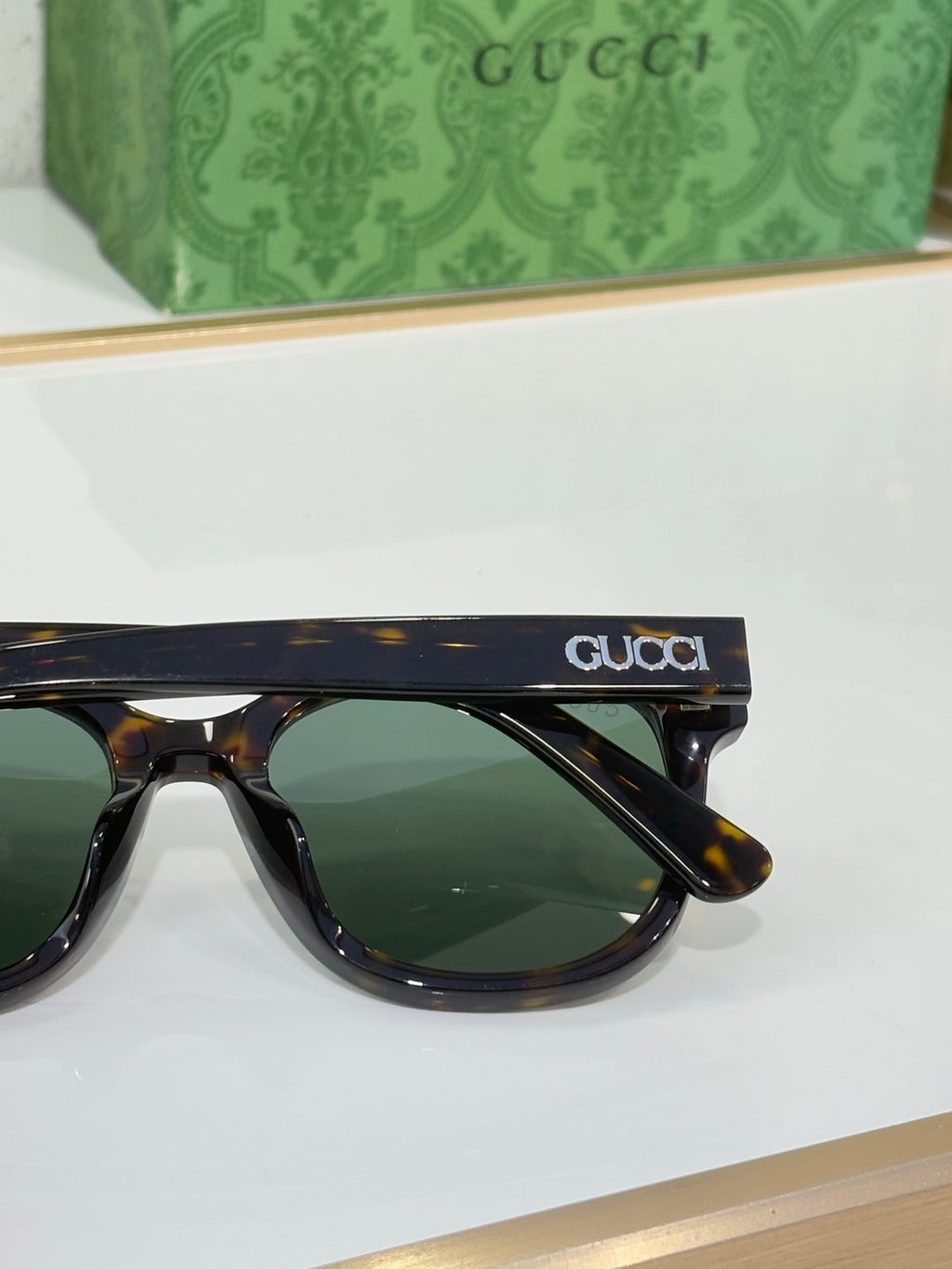 Gucci sunglasses side view with dark tinted lenses and logo on temple