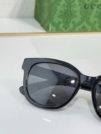Gucci sunglasses close-up with dark round lenses and glossy black frame