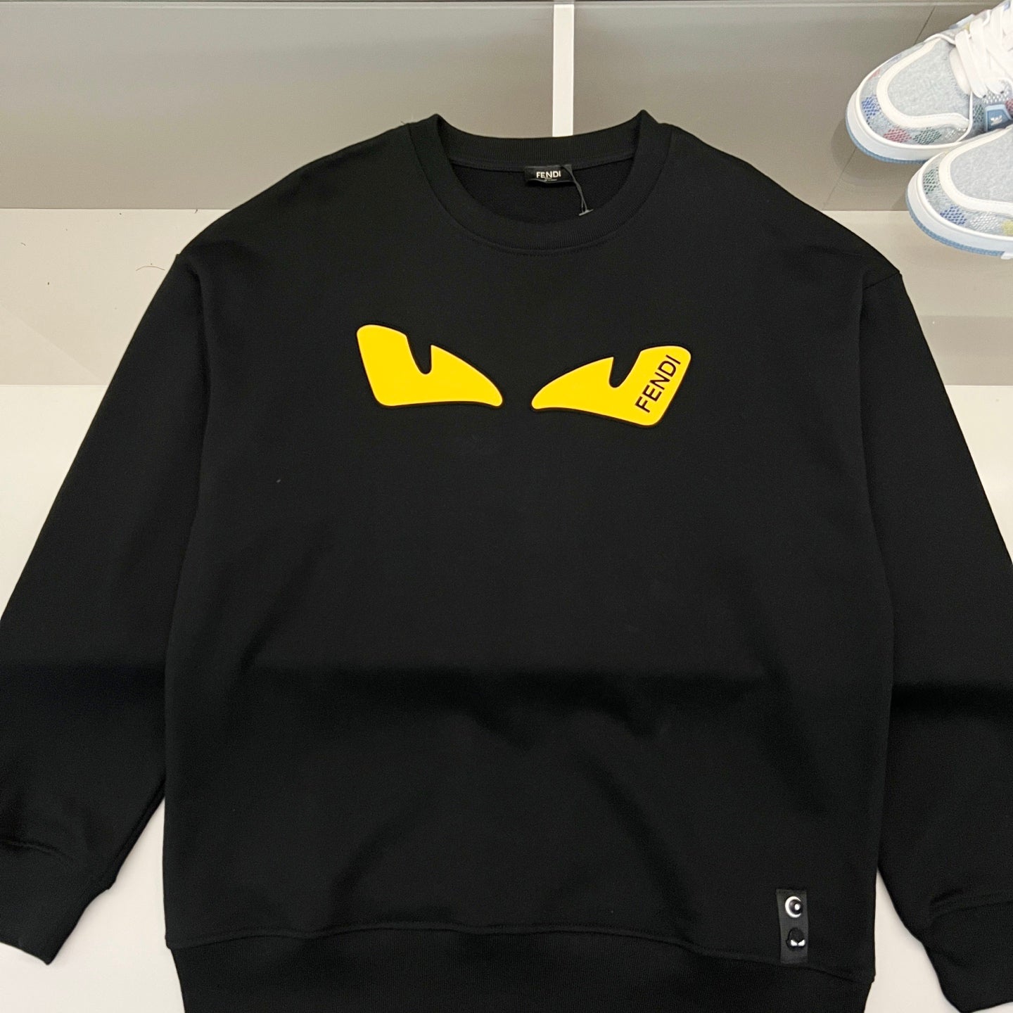 Black Fendi sweatshirt front with yellow graphic logo patch